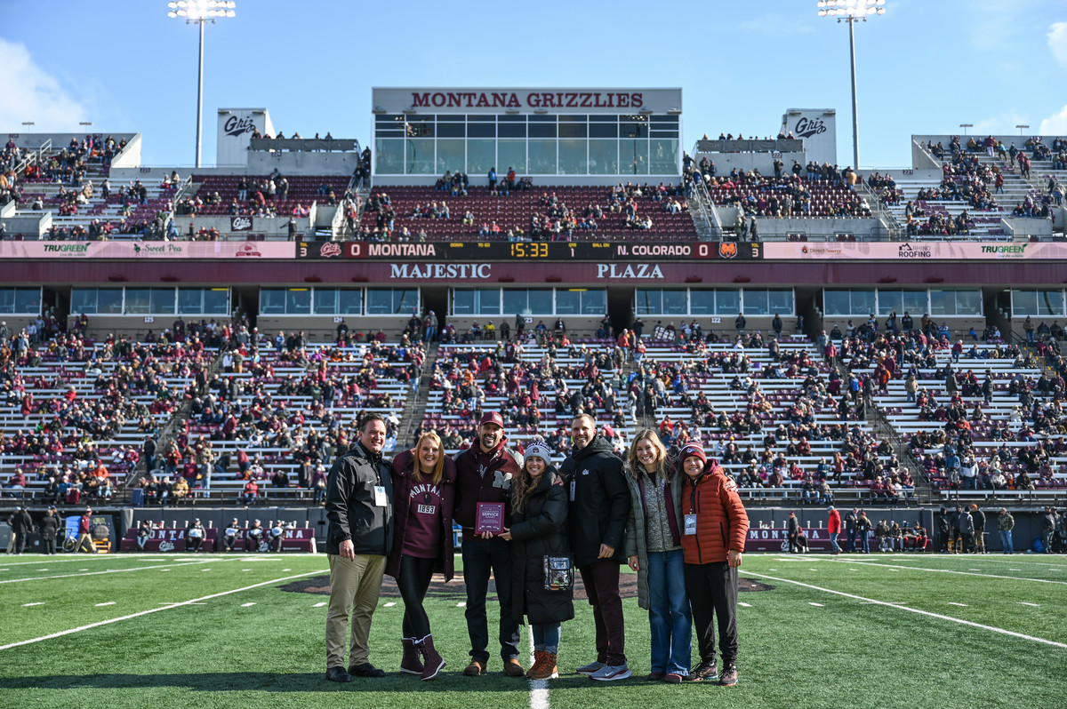 Beth and Brian Toone on field with University dignitaries