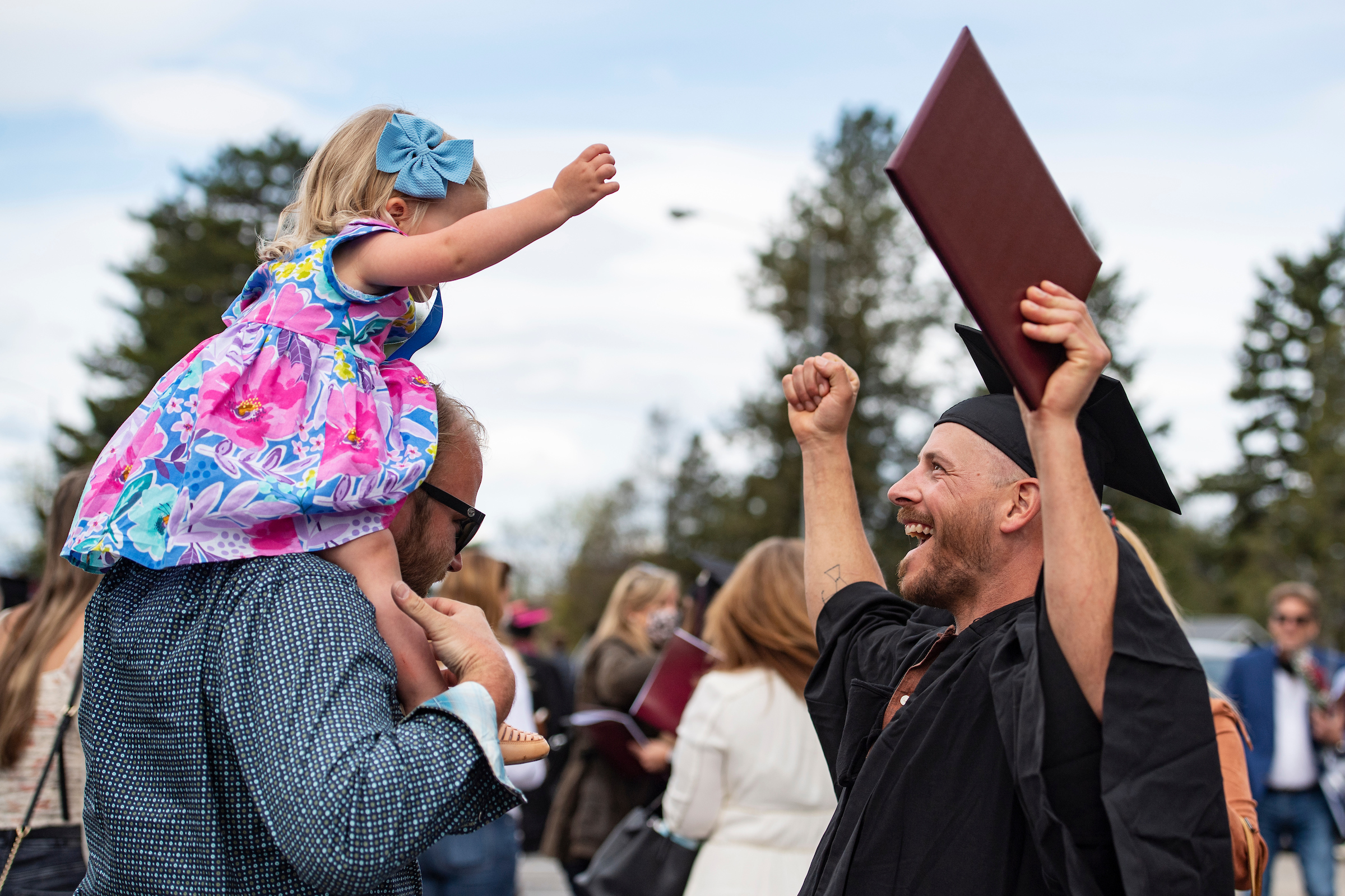 Graduate and child celebrate at commencement